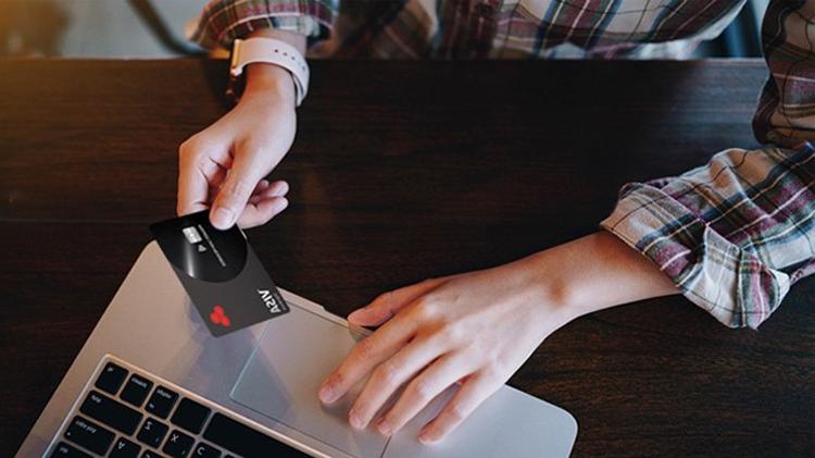 Person using their laptop while making an online purchase with a credit card.